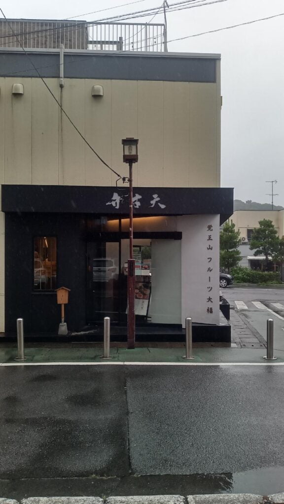 外観が特徴的な覚王山フルーツ大福店、雨の日の静かな街並みとともに。