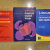 木製のテーブルの上に置かれた3冊の英語の辞書